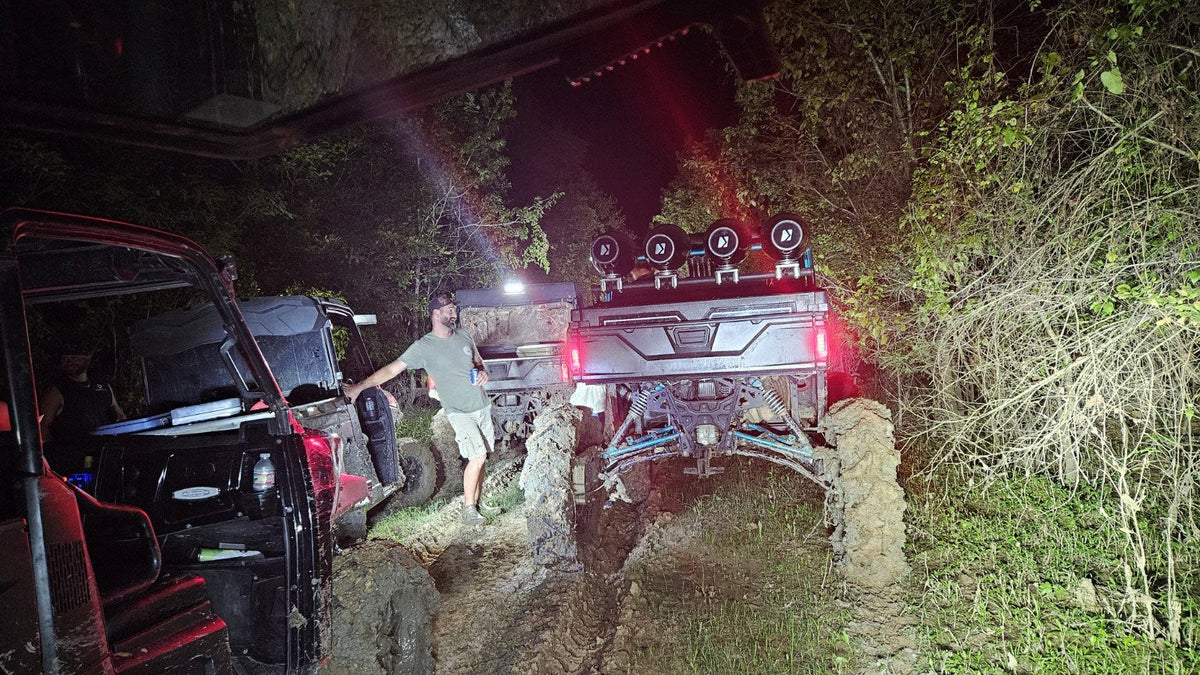 Muddy side-by-sides gathered on a night trail ride