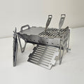 Slot Grill Compact with a solid griddle plate on one half and a slotted grate on the other, spare grate in front